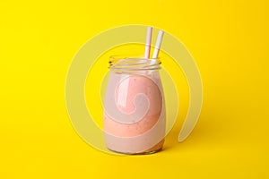 Delicious strawberry milkshake on yellow background Summer drink