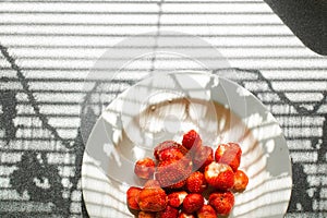 Delicious strawberry in a plate in sunlight.