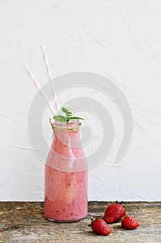 Delicious strawberry smoothie with milk, ice cream, green mint