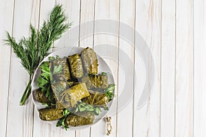 Delicious stuffed grape leaves traditional doom Mediterranean cuisine Dolma on a black plate with fresh cilantro and dill