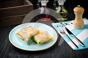 Delicious stuffed pancakes on wooden background