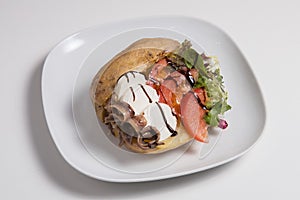 Delicious stuffed sweet potato with cheese, anchoa, tomato and salad photo