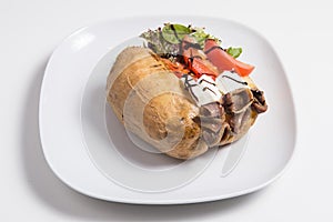Delicious stuffed sweet potato with cheese, anchoa, tomato and salad photo