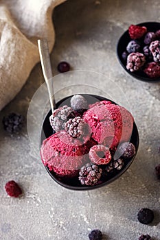 Delicious summer berries yogurt ice cream with berries on grey background, frozen berries, vegetarian ice cream