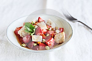 Delicious summer salad. Salad bowl with strawberries, tomatoes, pistachios and croutons