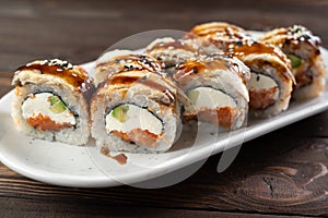 Delicious sushi roll topped with smoked eel and sesame seed. Sushi roll with avocado and crab meat. sushi dish