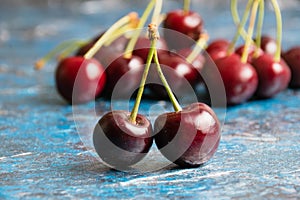 Delicious sweet cherry macro on blue textured background with copy space, berries close up