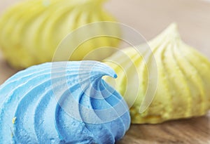 Delicious and sweet meringue in blue and yellow close-up