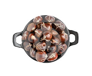 Delicious sweet roasted edible chestnuts in frying pan isolated on white, top view