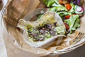 Delicious taco with guacamole and chapulines accompanied by a green salad