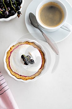 Delicious tart decorated with burned merengue and berries, served in white composition, with copy space. Top view.