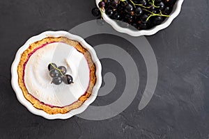 Delicious tart decorated with burned merengue and berries, served in white rustic composition, with copy space. Top view