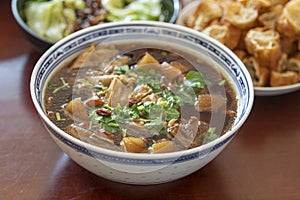 Delicious and tasty Bah Kut Teh pork rib soup served with stir ice salad and fried onion plus fired bread. This a typical photo