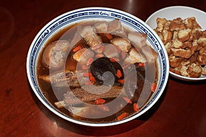 Home made delicious and tasty Bah Kut Teh pork rib soup served with stir ice salad and fried onion plus fired bread. photo