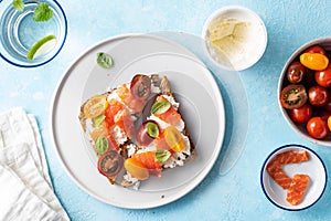 Delicious and tasty sandwich with salmon, basil, cherry tomatoes and caper. Close up selective focus. Traditional