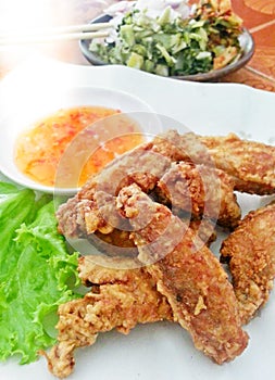 Delicious tasty Thai Golden Fried chicken wings in a plate with sauce Food background close up