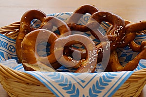 Delicious traditional Bavarian pretzels with brown salty crust on traditional Bavarian cocktail napkin in basket