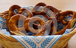 Delicious traditional Bavarian pretzels with brown salty crust on traditional Bavarian cocktail napkin in basket