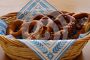 Delicious traditional Bavarian pretzels with brown salty crust on traditional Bavarian cocktail napkin in basket