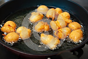 Delicious and traditional Brazilian homemade sweet called BOLINHO DE CHUVA being fried in a frying pan photo