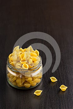 Delicious traditional conchiglie paste shells Italian macaroni pasta in the glass jar