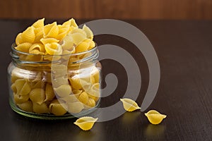 Delicious traditional conchiglie paste shells Italian macaroni pasta in the glass jar
