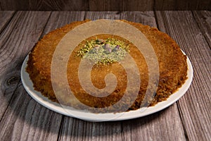 Delicious Traditional Dessert Knafeh with cheese and pistachios and orange flower syrup