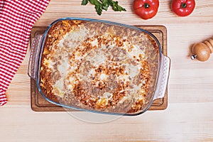 Delicious traditional italian lasagna made with minced beef bolognese sauce on wooden table