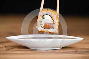 delicious traditional Japanese sushi and rolls on a plate holding chopsticks