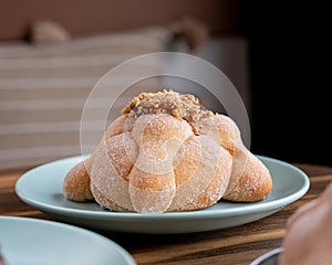 Delicious traditional mexican pan de muerto, with cajeta on top, sugar, inside a coffee, for the day of the dead, mexican culture