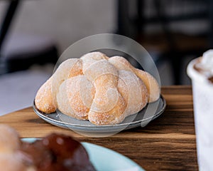 Delicious traditional mexican pan de muerto, with cajeta on top, sugar, inside a coffee, for the day of the dead, mexican culture