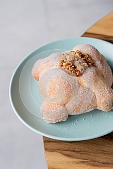Delicious traditional mexican pan de muerto, with cajeta on top, sugar, inside a coffee, for the day of the dead, mexican culture