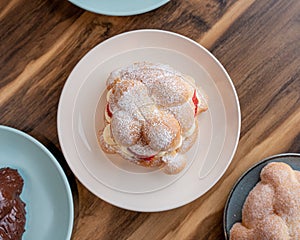 Delicious traditional mexican pan de muerto, filled with delicious cream, with red fruits inside, strawberries and blackberries