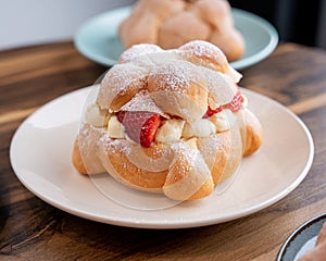 Delicious traditional mexican pan de muerto, filled with delicious cream, with red fruits inside, strawberries and blackberries