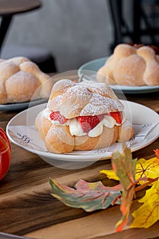 Delicious traditional mexican pan de muerto, filled with delicious cream, with red fruits inside, strawberries and blackberries