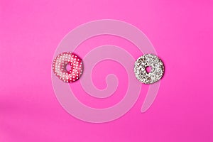 Delicious two donuts, pink and white on color background, top view