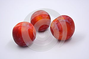 Delicious useful fruits, red, cherry ripe plums located on a white background.
