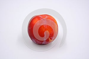 Delicious useful fruits, red, cherry ripe plums located on a white background.