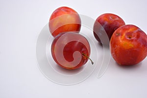 Delicious useful fruits, red, cherry ripe plums located on a white background.