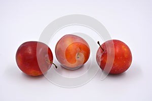 Delicious useful fruits, red, cherry ripe plums located on a white background.