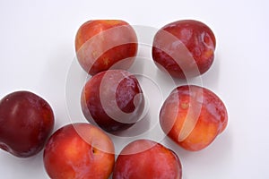 Delicious useful fruits, red, cherry ripe plums located on a white background.