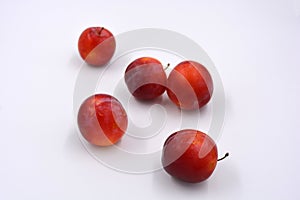 Delicious useful fruits, red, cherry ripe plums located on a white background.