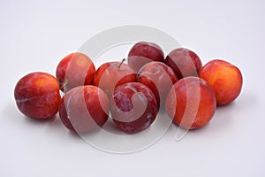 Delicious useful fruits, red, cherry ripe plums located on a white background.