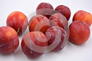 Delicious useful fruits, red, cherry ripe plums located on a white background.