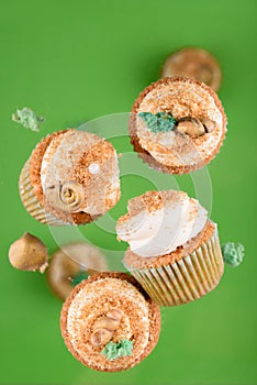 Delicious vanilla cupcakes with festive sparkles on a green background.