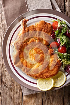 Delicious veal cutlet Milanese with lemon and fresh vegetable sa