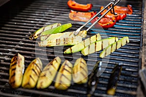 Delicious vegetables grilling in open grill, outdoor kitchen. food festival in city. tasty food peppers zucchini roasting on baske