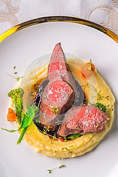 Delicious venison steak with potatoes mash and vegetables on white plate, product photography for exclusive restaurant