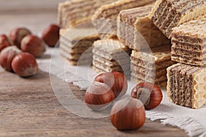 Delicious wafers with hazelnuts on brown wooden background