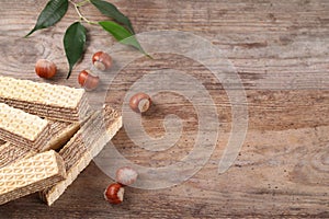 Delicious wafers with hazelnuts on brown wooden background